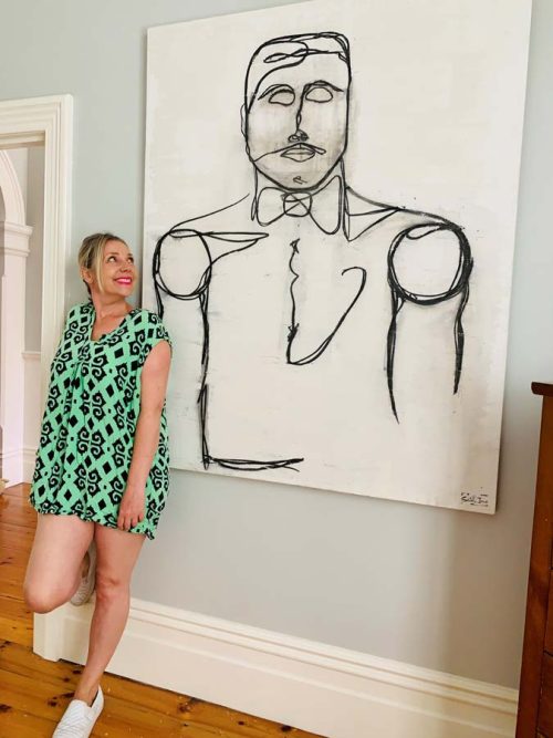 Sarah Jane standing next to Linear I painting - gentleman line art